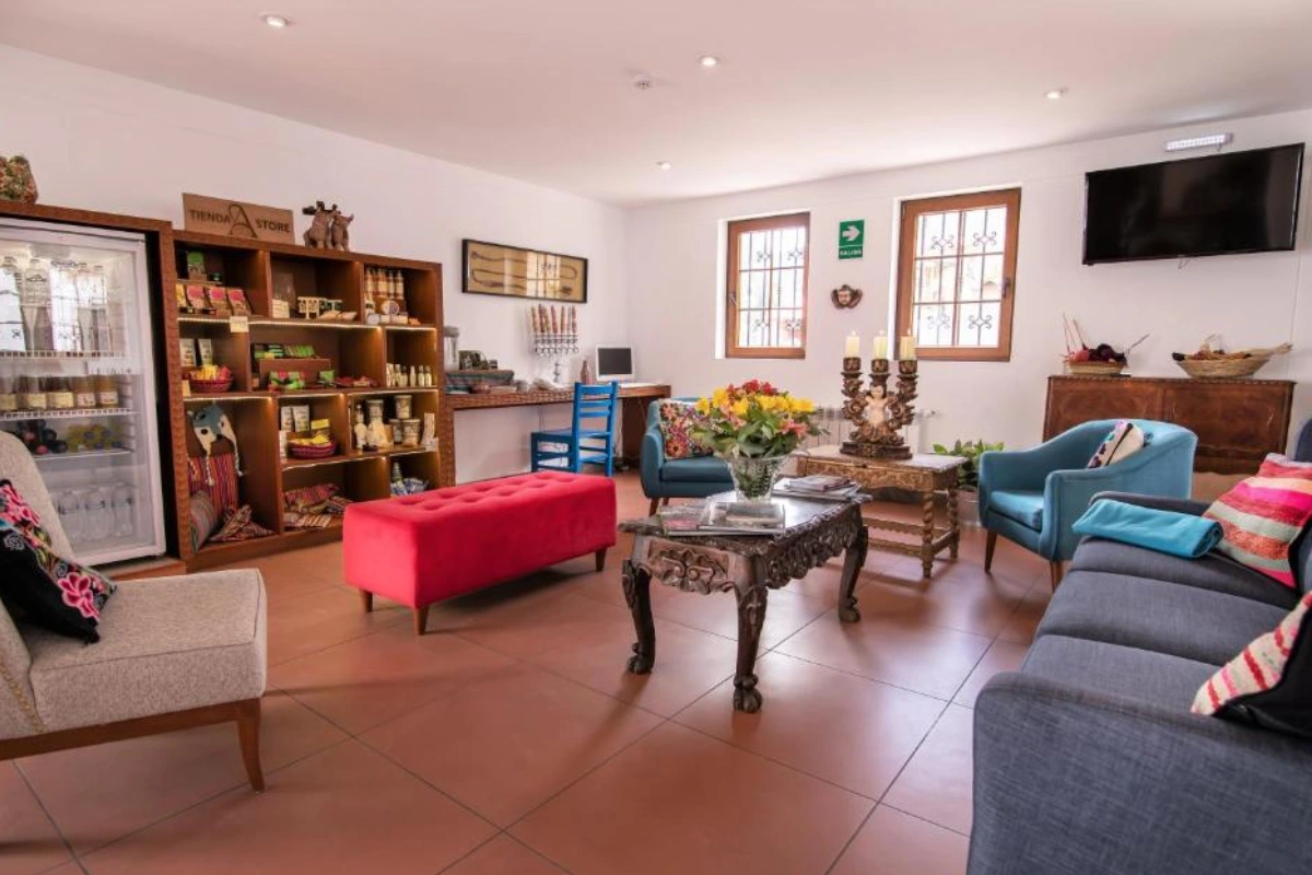 Sala común del Atoq San Blas Hotel, con sofás, decoración colorida y ambiente acogedor en el barrio de San Blas, Cusco.