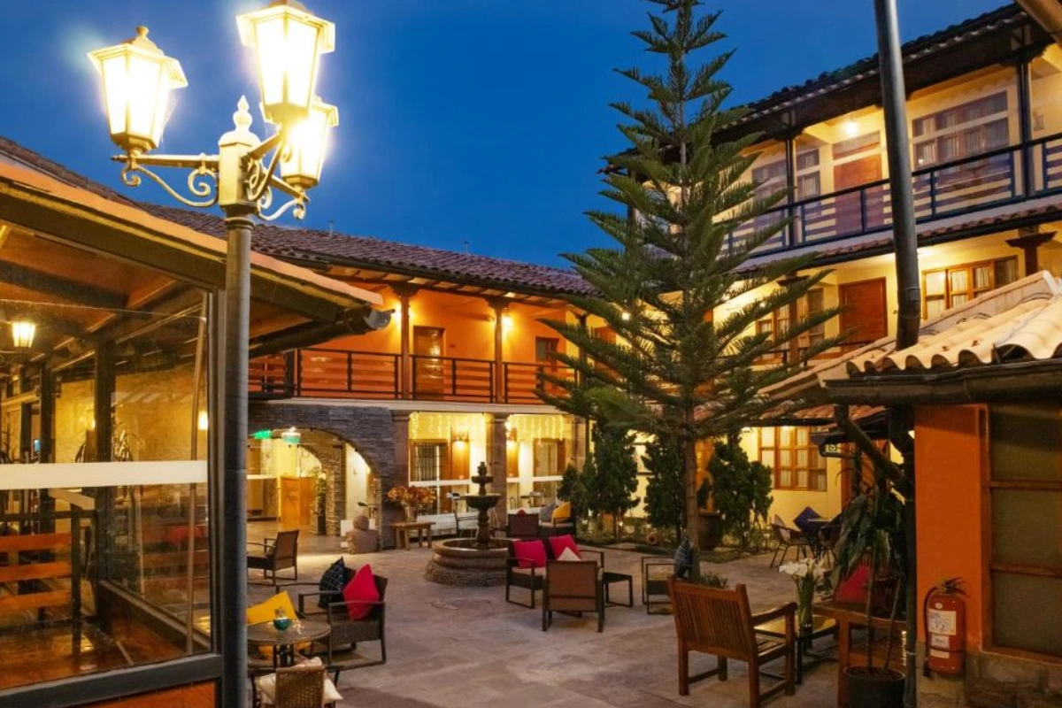 Patio interior del Union Hotel Cusco, con áreas de descanso, iluminación cálida y ambiente acogedor en una casona del centro histórico de Cusco.