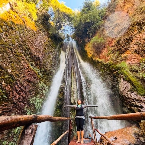 Mujer debajo de las cataratas de poc poc