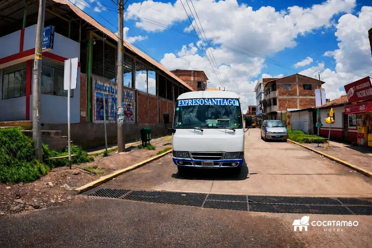 Bus de transporte urbano Expreso Santiago en una calle de Cusco bajo cielo azul con nubes.