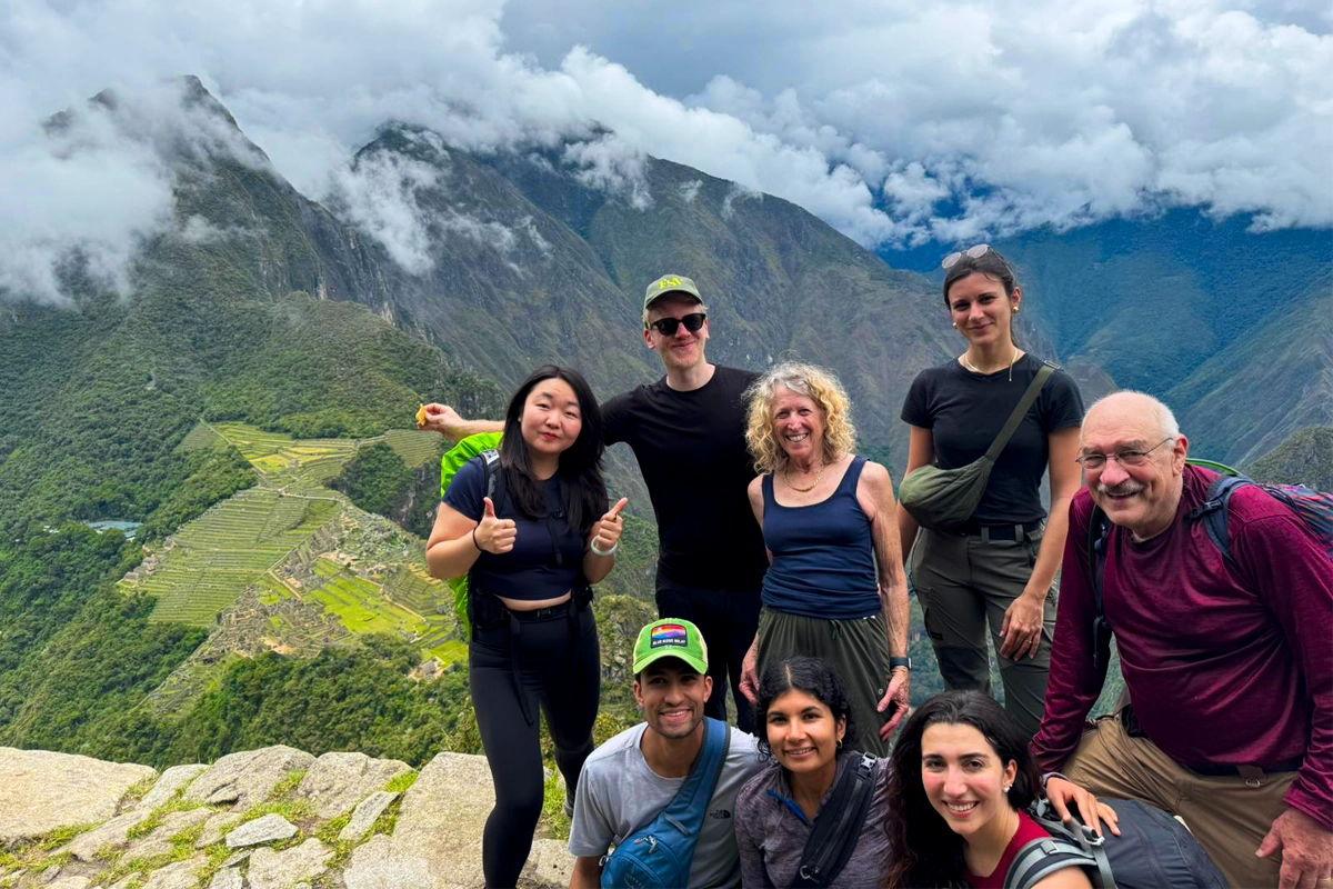 Grupo de viajeros en la Montaña Huayna Picchu con vista elevada de la ciudadela inca