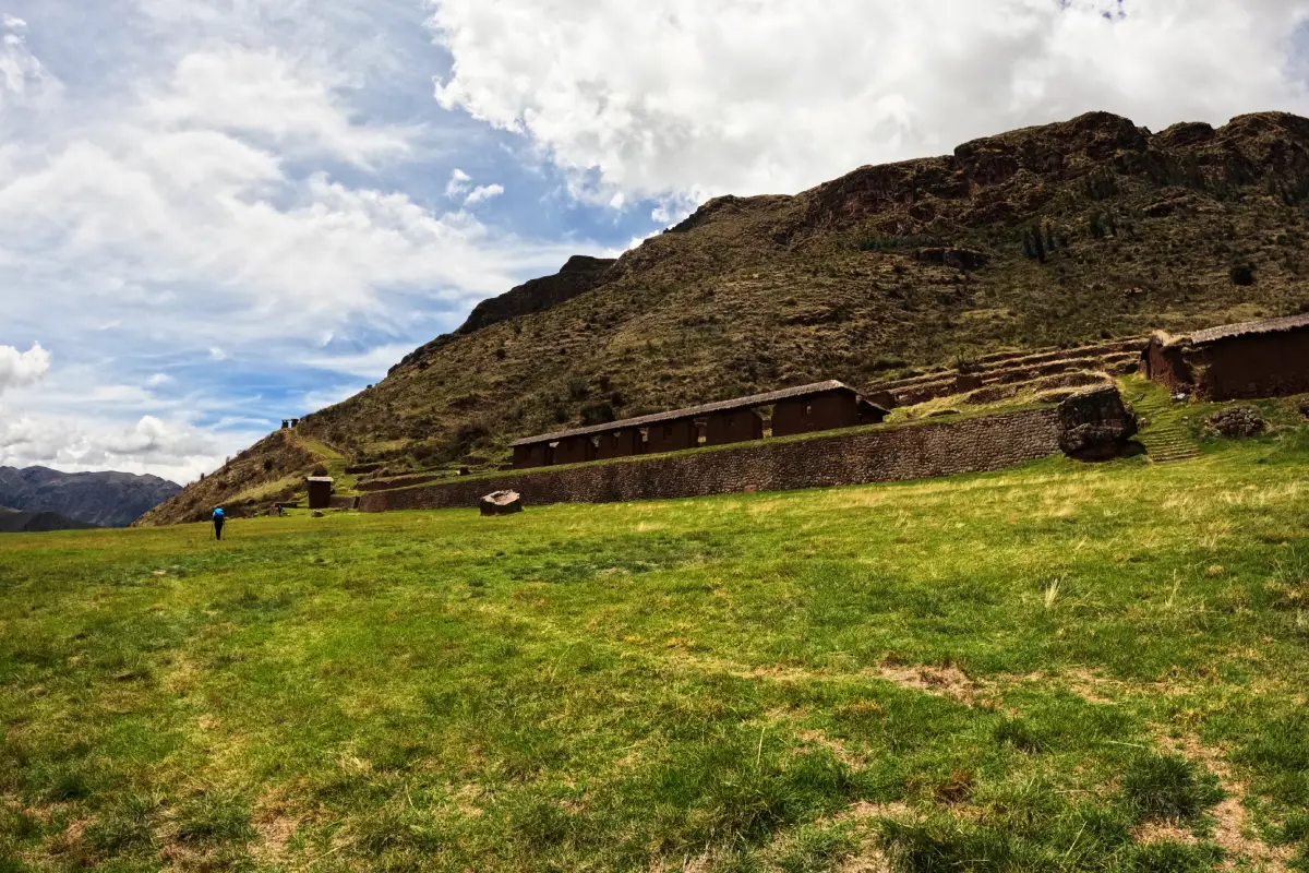 Campo verde y estructuras de Huchuy Qosqo bajo la montaña | Cocatambo