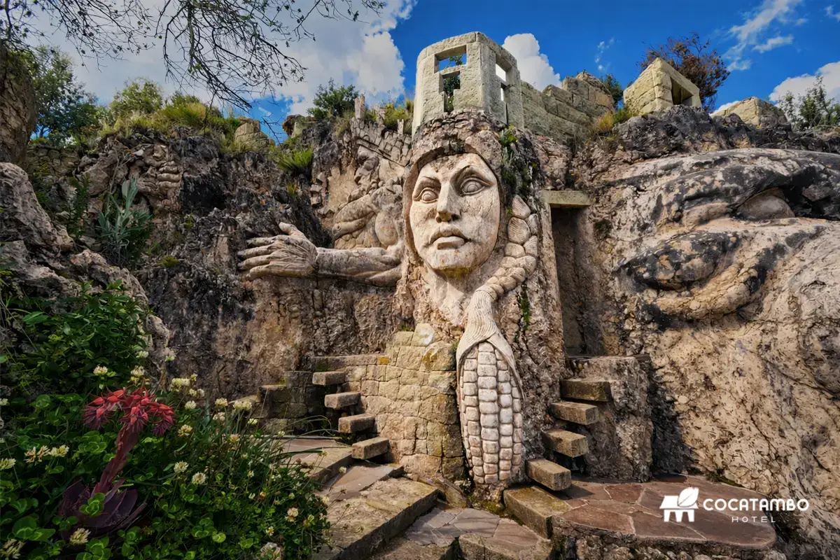 Escultura de Mama Sara tallada en piedra con detalles simbólicos y escalinatas laterales.