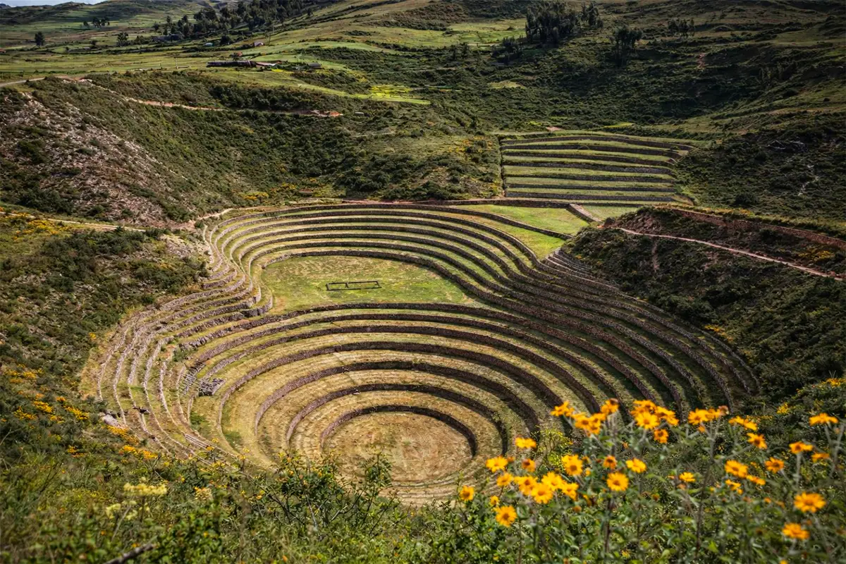 Andenes de Moray en el Valle Sagrado, con terrazas concentricas y paisaje verde alrededor