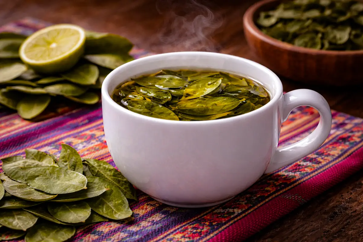 Mate de coca caliente preparado con hojas de coca, una infusión andina tradicional usada para ayudar a aliviar los síntomas del mal de altura.