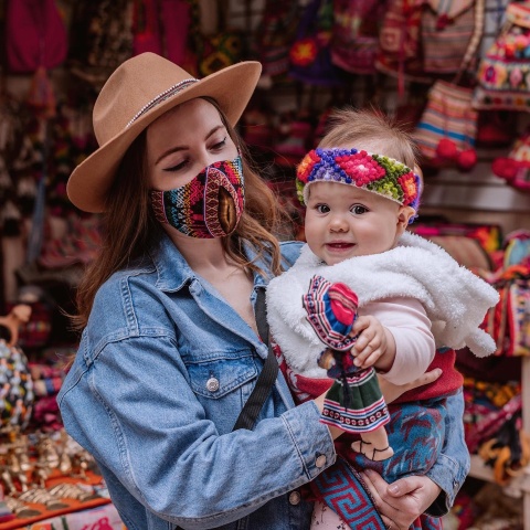 Turista con su bebe en el mercado de pisac