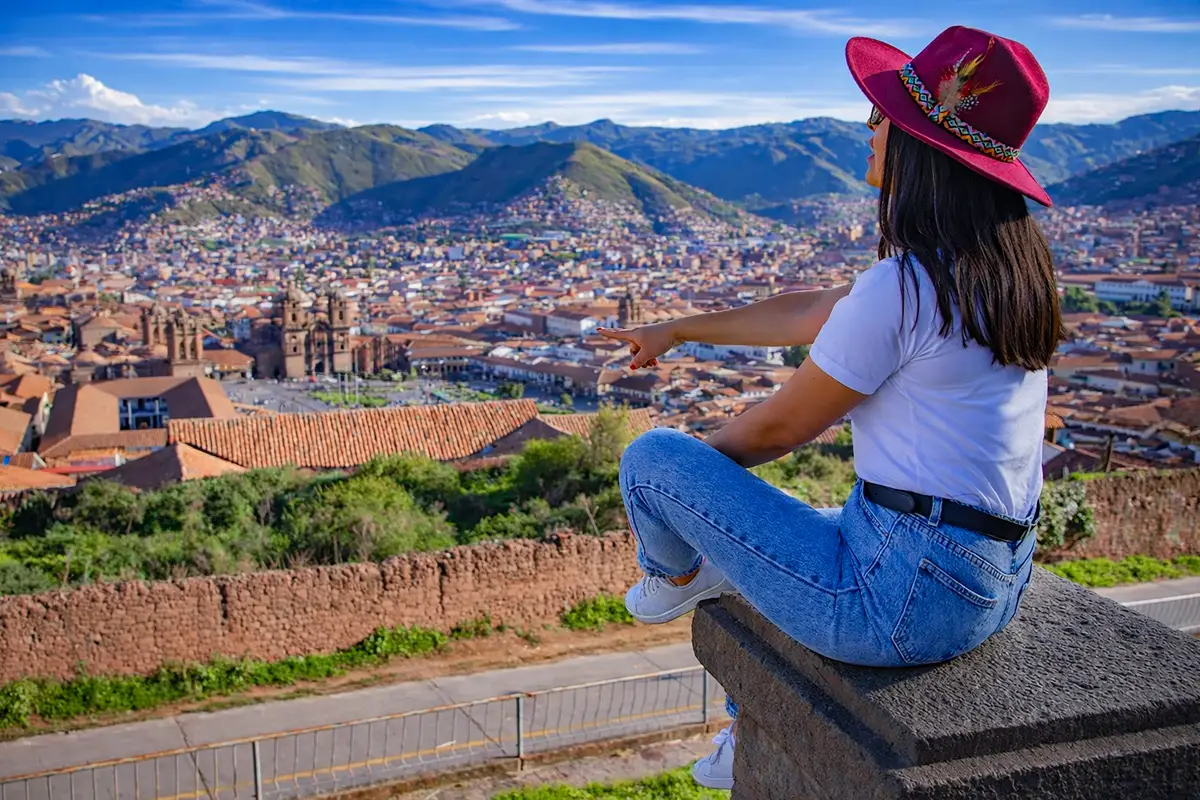 Chica señalando Cusco desde el mirado de San Cristóbal