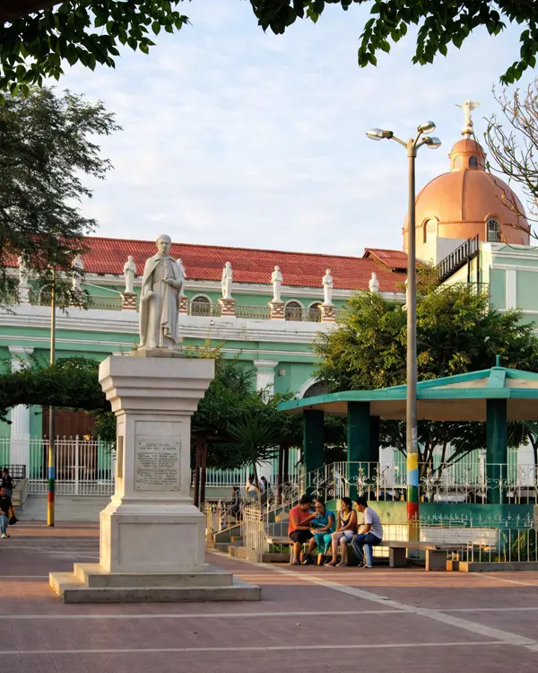 Plaza de Armas Catacaos con monumento y edificio histórico de fachada verde en Catacaos