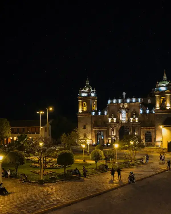 Plaza e iglesia iluminadas de noche en una ciudad andina del Perú