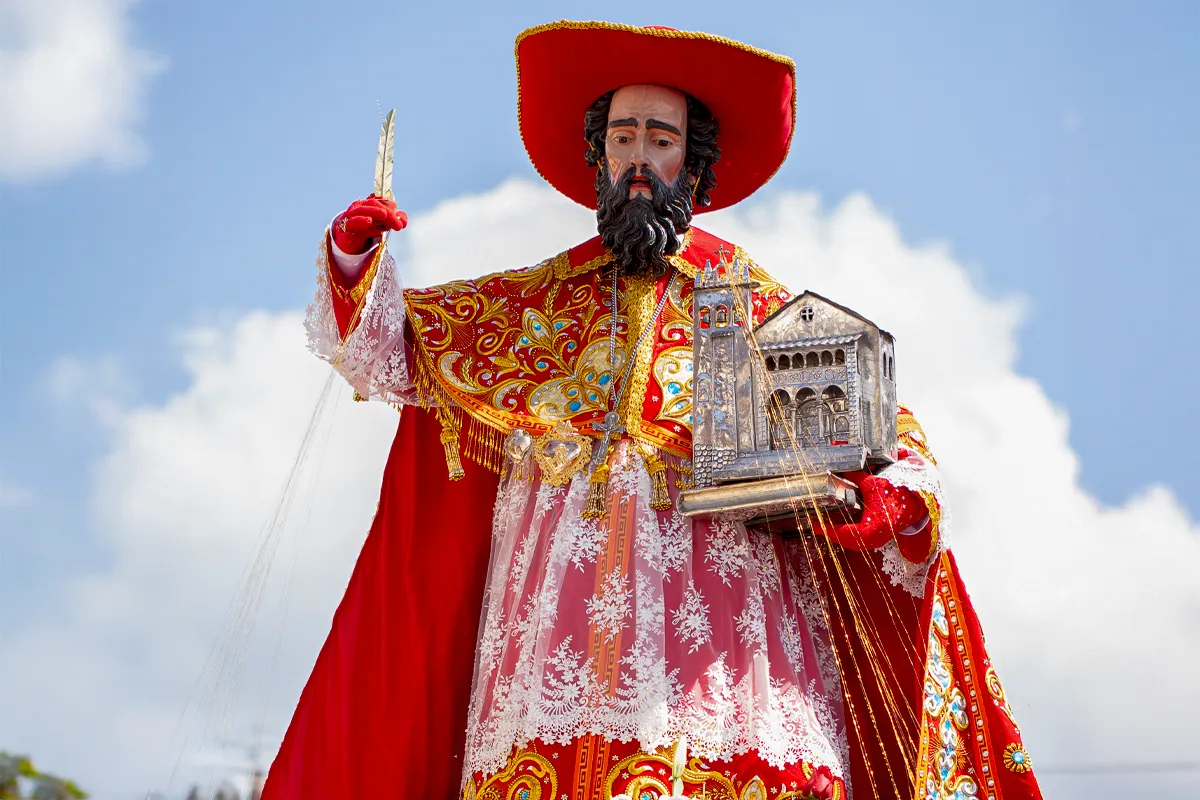 Imagen de San Jerónimo en el Corpus Christi de Cusco con vestimenta roja y maqueta de iglesia en las manos