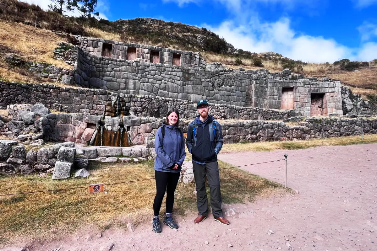 Pareja frente a muros incas y baños del inca en Tambomachay | Cocatambo