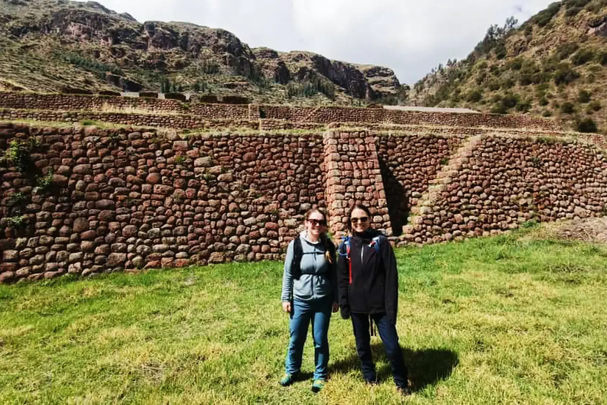 Pareja de excursionistas frente a un gran muro inca de piedra | Cocatambo