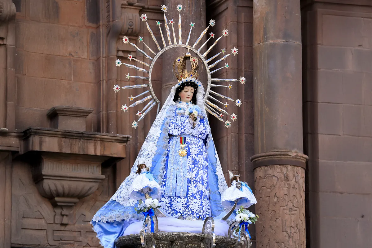 Imagen de la Virgen Inmaculada en andas durante el Corpus Christi de Cusco frente a un templo colonial